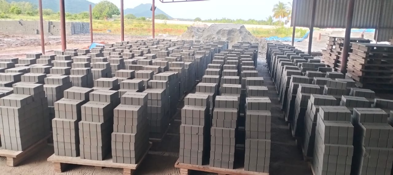 Rows of finished flyash brick pallets stacked inside the TVM Bricks Thondamuthur facility